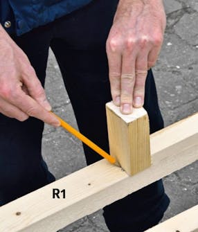 Rammedele til utebod måles opp De fire rammedelene til uteboden måles opp